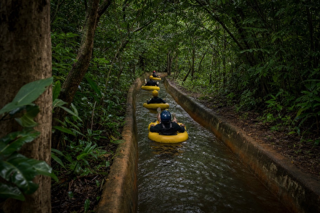 Inner tubes floating down a historic plantation irrigation canal through Kauai jungle on a mountain tubing tour